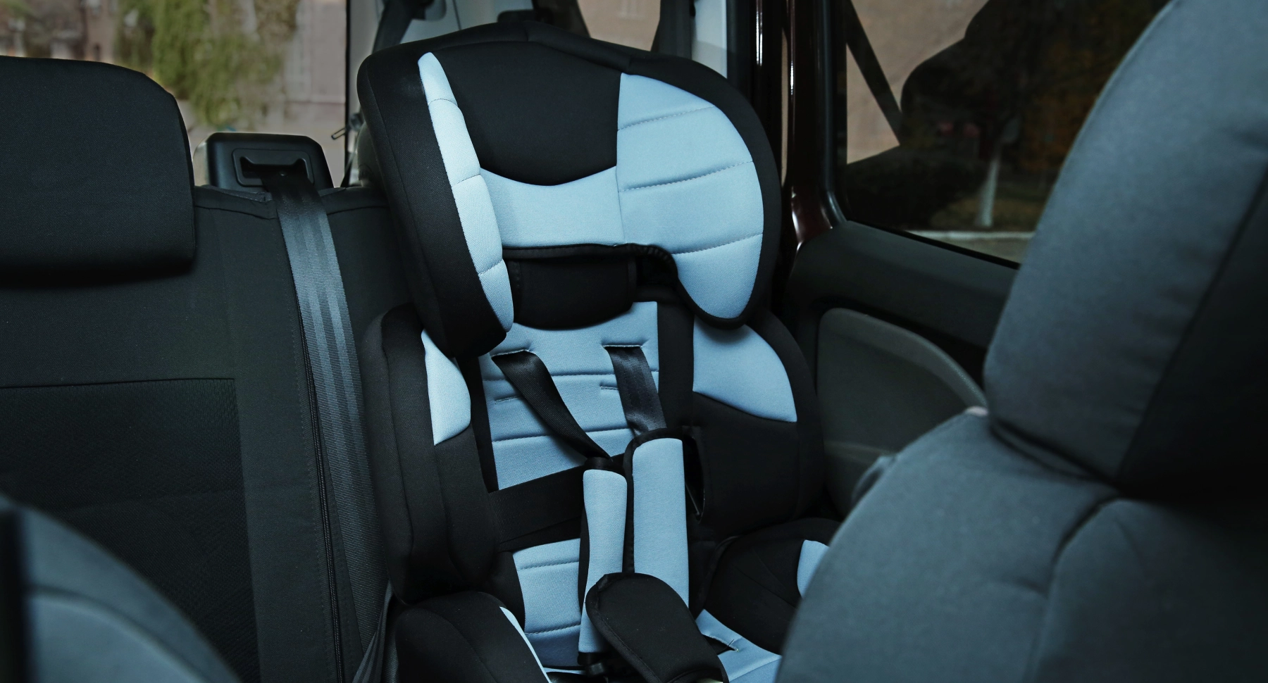 a blue child booster seat in backseat of a car