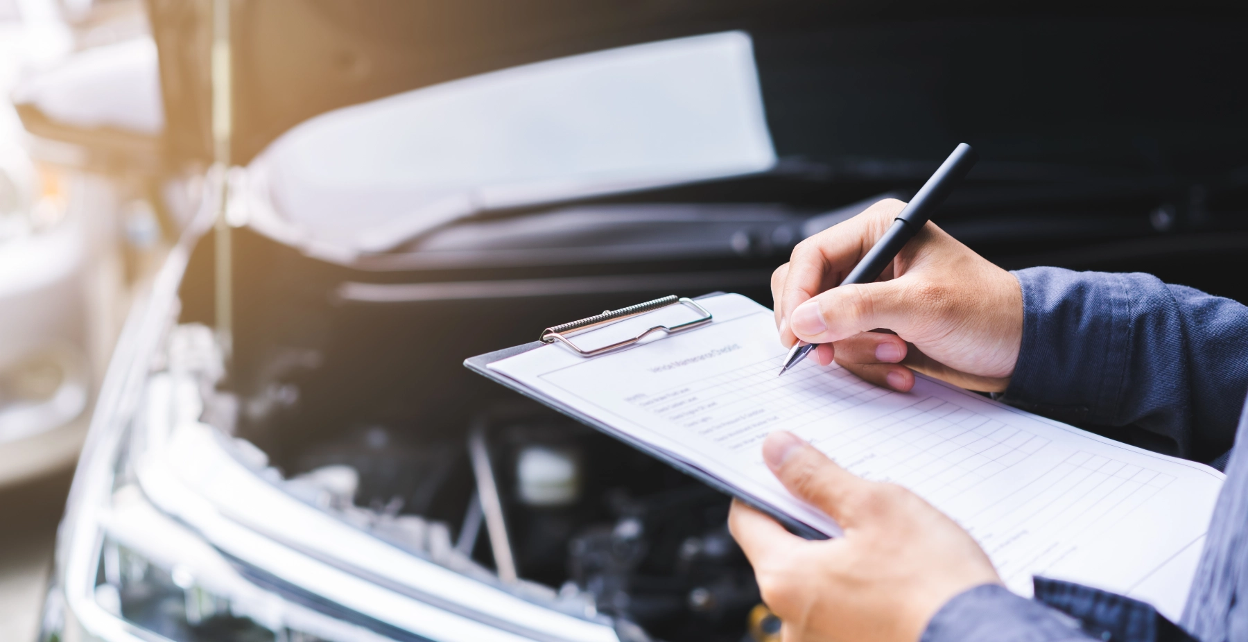 person standing in front of a vehicle with a clip board
